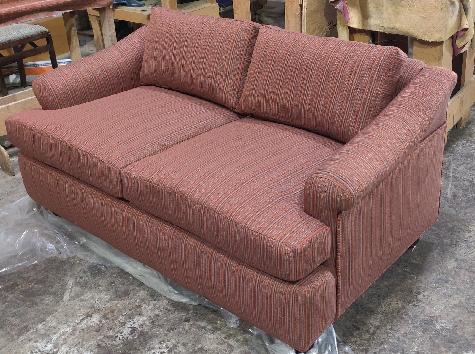 Custom rust-toned rolled-arm loveseat for an office lobby