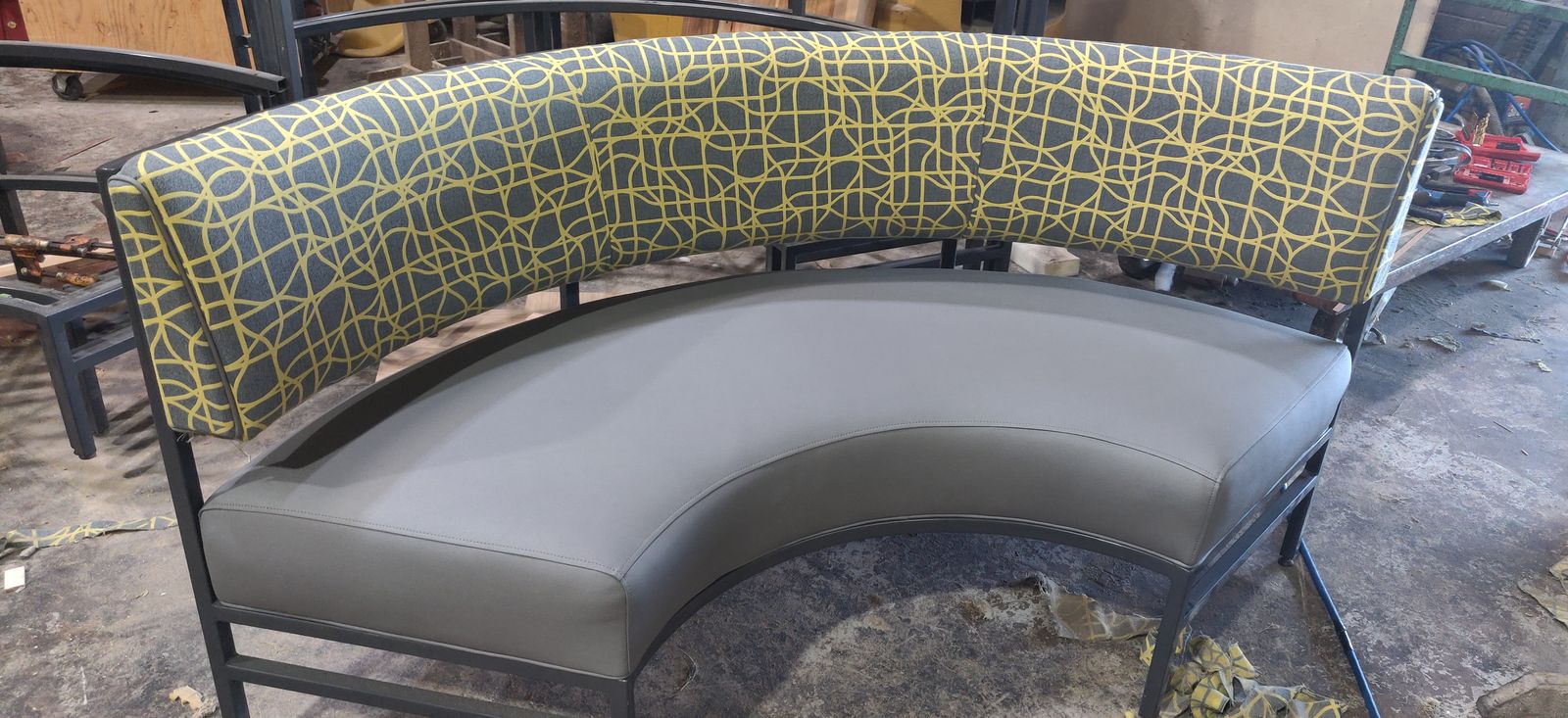 Half-circle metal-framed booth with gray vinyl seat and yellow patterned back, The Breakfast Club