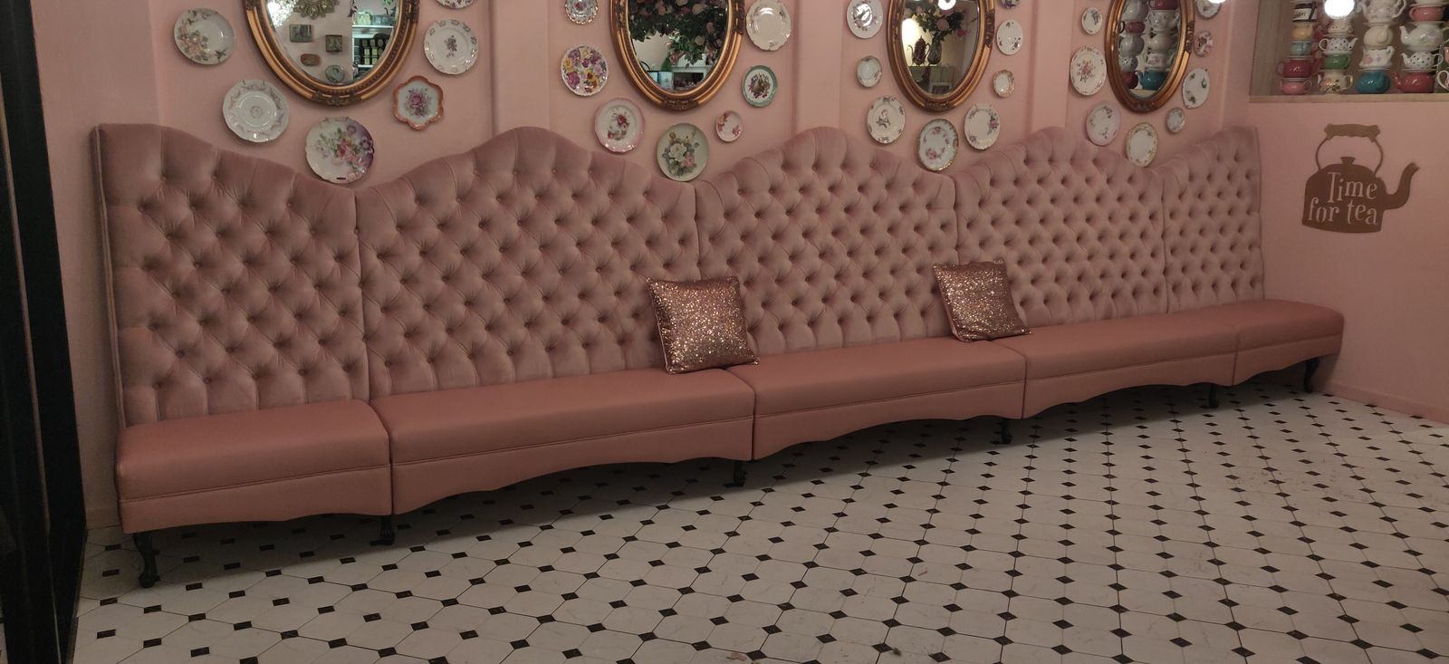 Pink tufted banquette wall with brass mirrors, English Rose Tea Room in Carefree, AZ