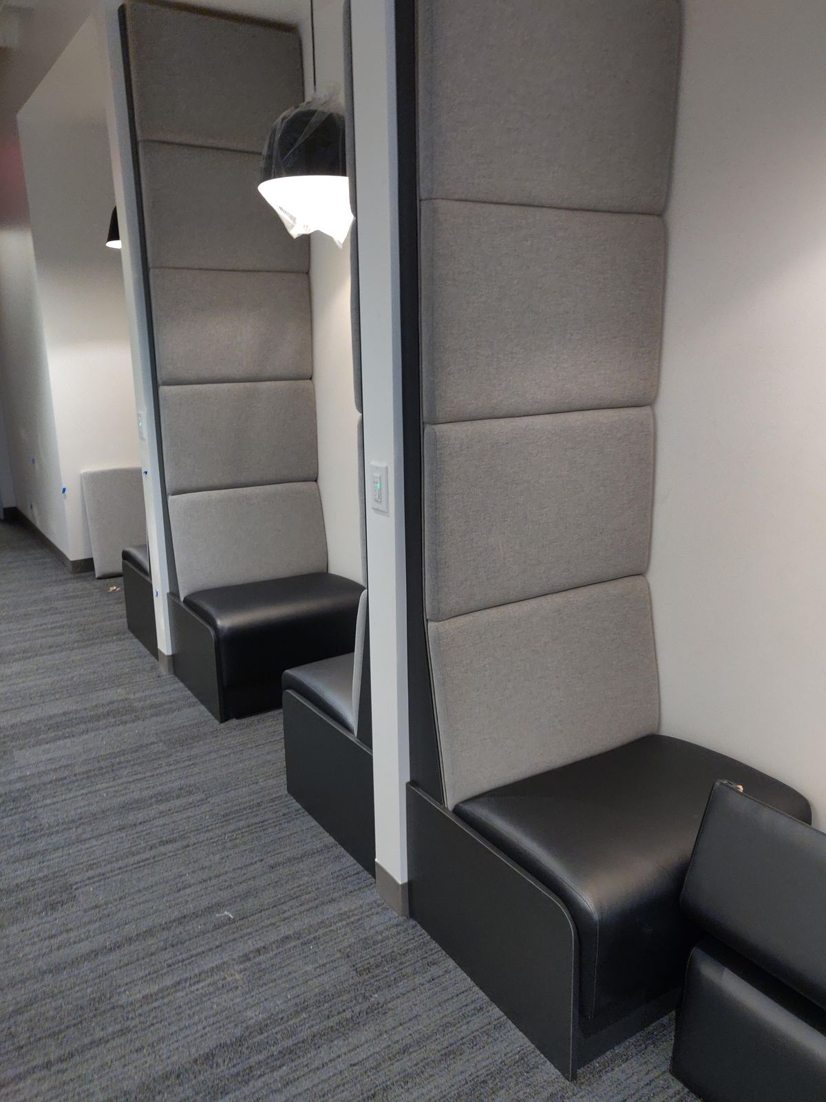 Row of tall-back lounge seats with pendant lighting, Alaska Airlines waiting area